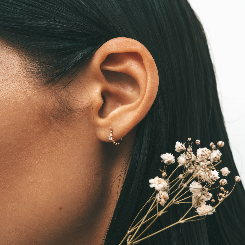Close-up shot of a woman's ear with Sceona Roucou hoops earrings on