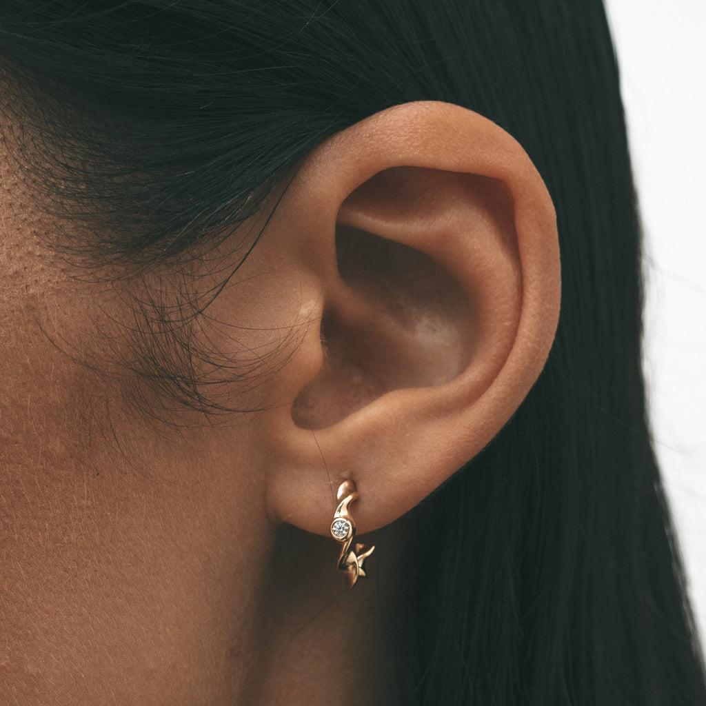 Close-up shot of a woman's ear with Sceona Ceiba hoops earrings on